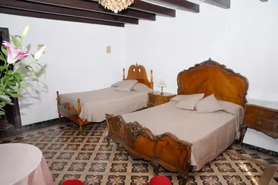 a bedroom with two beds and a chandelier at Ca la Paula in Pla del Panadés