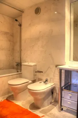 a white bathroom with a toilet and a sink at Barcelona Olympic Apartment in Barcelona