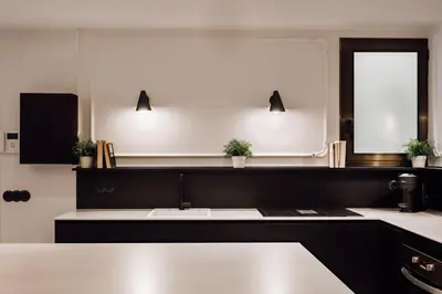 a kitchen with a sink and two lights on the wall at Lunalux Apartment in Barcelona
