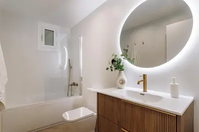 a bathroom with a sink and a toilet and a mirror at Lunalux Apartment in Barcelona