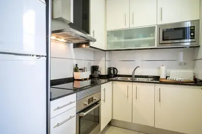 a kitchen with white cabinets and stainless steel appliances at The Family Host - Lost Garden Ciutadella Park in Barcelona
