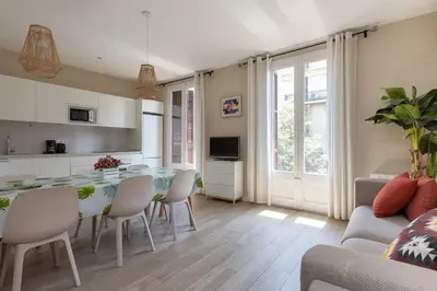 a kitchen and living room with a table and chairs at ApartEasy - Family 4-Bedroom Apartment in Barcelona