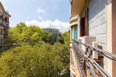 an apartment balcony with a view of trees and buildings at ApartEasy - Family 4-Bedroom Apartment in Barcelona
