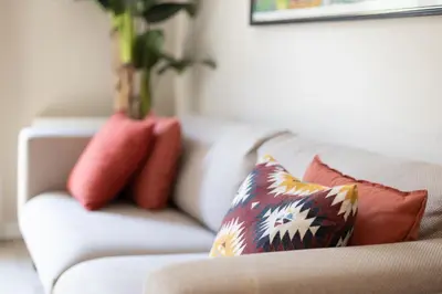 a white couch with pillows and a vase on it at ApartEasy - Family 4-Bedroom Apartment in Barcelona