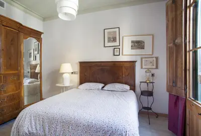 a bedroom with a large bed with a wooden headboard at ApartEasy - Authentic Family Apartment in Barcelona