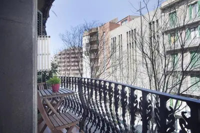 a balcony with two benches on a railing with buildings at ApartEasy - Authentic Family Apartment in Barcelona