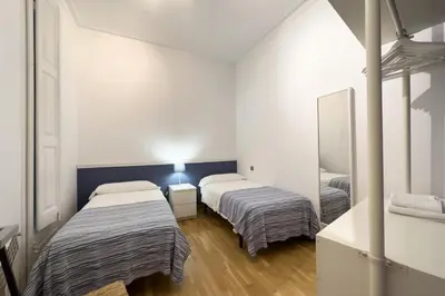 a room with two beds and a mirror at ApartEasy - Passeig de Gracia in Barcelona