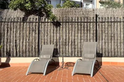 two chairs and a table in front of a fence at ApartEasy - Passeig de Gracia in Barcelona