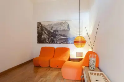 a living room with two orange chairs and a table at ApartEasy - Atic Sagrada Familia in Barcelona