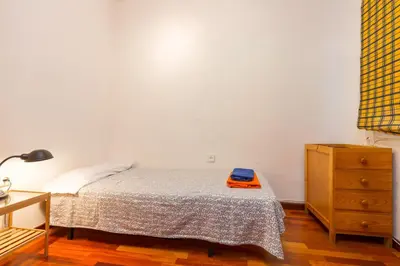 a small bedroom with a bed and a dresser at ApartEasy - Port Barcelona in Barcelona