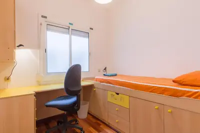 a bedroom with a desk and a bed and a chair at ApartEasy - Port Barcelona in Barcelona