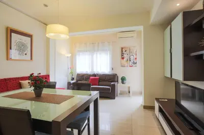a kitchen and living room with a table and a couch at ApartEasy - Family Apartment Sant Antoni in Barcelona