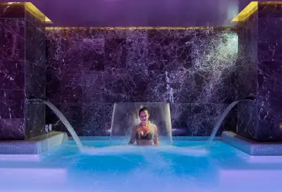 a woman is sitting in a hot tub in a swimming pool at The One Barcelona GL in Barcelona