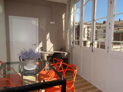 a dining room with a glass table and orange chairs at Feel at Sants Apartments in Barcelona