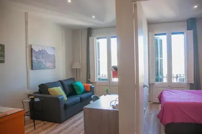a living room with a couch and a bed at Feel at Sants Apartments in Barcelona