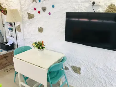 a white table with chairs and a tv on a wall at Heart of Gracia in Barcelona