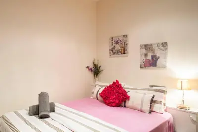 a bedroom with a bed with red flowers on it at Tendency Plaza España in Barcelona