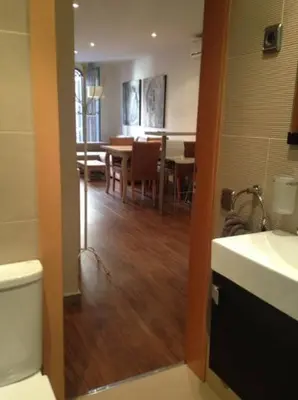 a bathroom with a toilet and a dining room at Tendency Plaza España in Barcelona