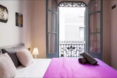 a bedroom with a large white bed with a window at Tendency Plaza España in Barcelona
