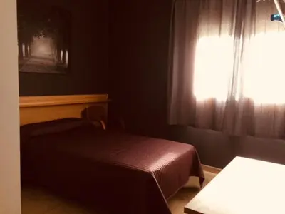 a bedroom with a bed and a window at Hostal del Carmen in Terrassa
