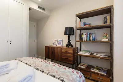 a bedroom with a bed and a book shelf at RAMBLA POBLENOU Luxury in Barcelona