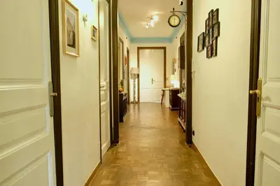 a corridor of a hallway with a clock on the wall at Grand Central Apartment in Barcelona