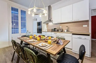 a kitchen with a wooden table and chairs at Sweett - La Pedrera - Paseo de Gracia in Barcelona