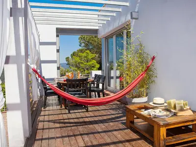 a hammock on a patio with a table and chairs at Holiday Home Ginesteres by Interhome in Argentona