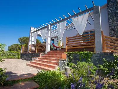 a set of stairs leading to a house with wooden benches at Holiday Home Ginesteres by Interhome in Argentona