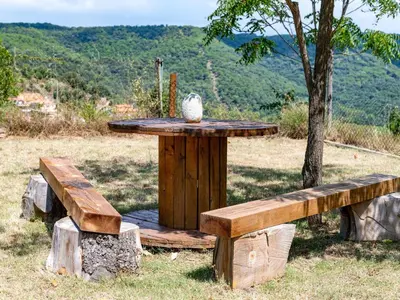 a wooden table and benches in a field at Holiday Home Ginesteres by Interhome in Argentona