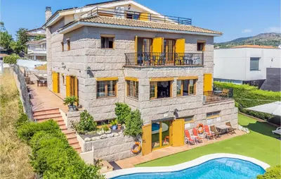 a large stone house with a pool in front of it at Gorgeous Home In Alella in Alella
