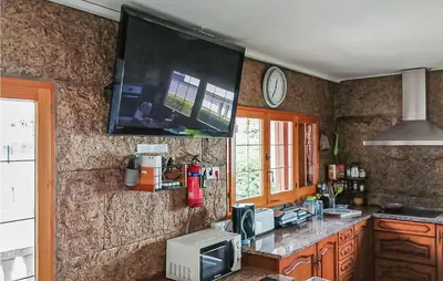 a kitchen with a tv hanging on the wall at Gorgeous Home In Alella in Alella