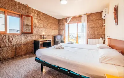 a bedroom with a large bed and a desk and window at Gorgeous Home In Alella in Alella