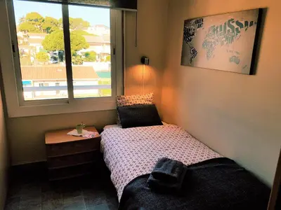 a small bedroom with a bed and a window at Marina Port & Beach-Apartment in Masnou