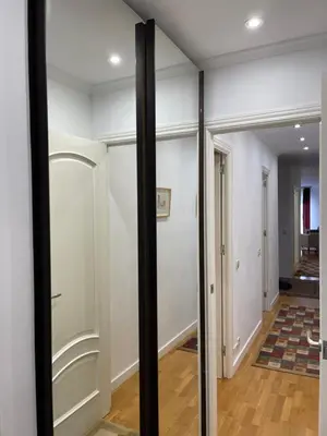 a hallway with white walls and glass doors at Channing Apartment in Barcelona