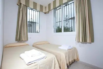 two beds in a room with two windows at Sunway Torre La Veleta in Sitges