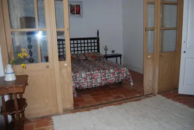 a bedroom with a bed and a wooden door at Can plana de baix in San Pol de Mar