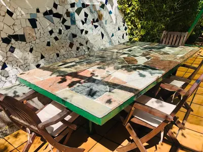 a table with two chairs and a mosaic wall at Apartamento Mar y Montaña in Argentona