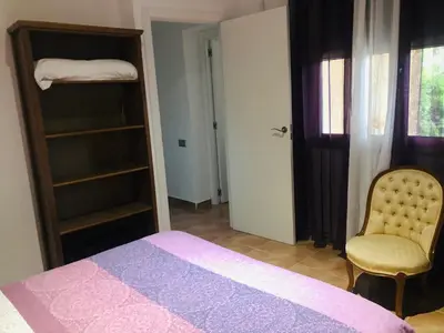 a bedroom with a bed and a chair and a closet at Apartamento Mar y Montaña in Argentona