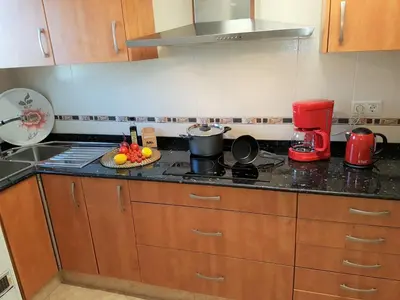 a kitchen with a stove and a bowl of fruit on the counter at Helena Seaview & Beach-apartment in Montgat