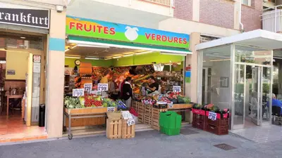 a fruit and vegetable store with a woman in front of it at Helena Seaview & Beach-apartment in Montgat