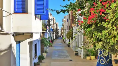 an alley between buildings with flowers and plants at Helena Seaview & Beach-apartment in Montgat