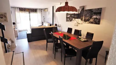 a dining room and living room with a table and chairs at Claire Seaview & Beach-apartment in Montgat