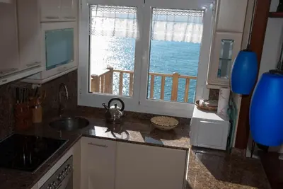 a kitchen with a view of the ocean from a window at Apartamento en acantilado con wifi y aire acondicionado in Sitges