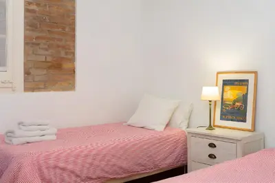 a bedroom with two beds and a picture on a night stand at Filmoteca Sarria 1- wifi quiet bright comfi in Barcelona