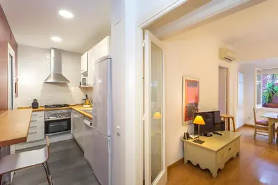 a kitchen with white walls and a desk with a computer at Filmoteca Sarria 1- wifi quiet bright comfi in Barcelona