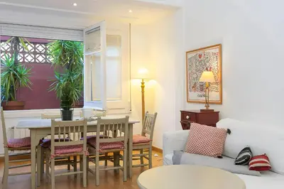 a living room with a table and chairs at Filmoteca Sarria 1- wifi quiet bright comfi in Barcelona