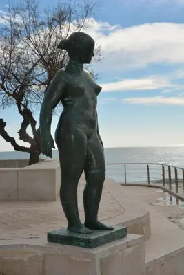 a statue of a woman standing next to the ocean at Apartamento Flavia II Sant Damià in Sitges