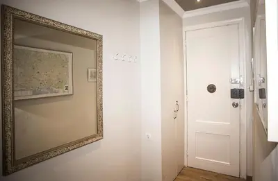 a mirror hanging on a wall next to a door at Mai & Maud Paralel Apartment in Barcelona