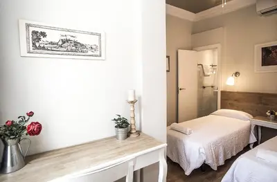 a white room with a bed and a table with flowers at Mai & Maud Paralel Apartment in Barcelona